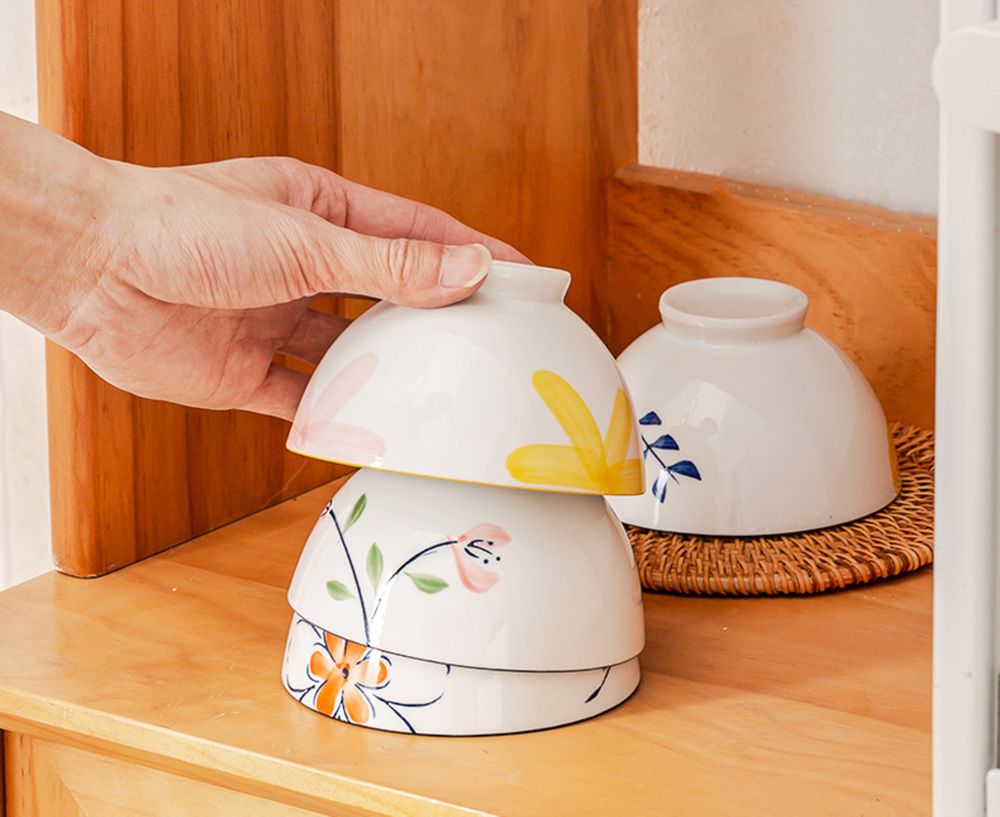 A slender white porcelain carafe with an inverted cup lid.
