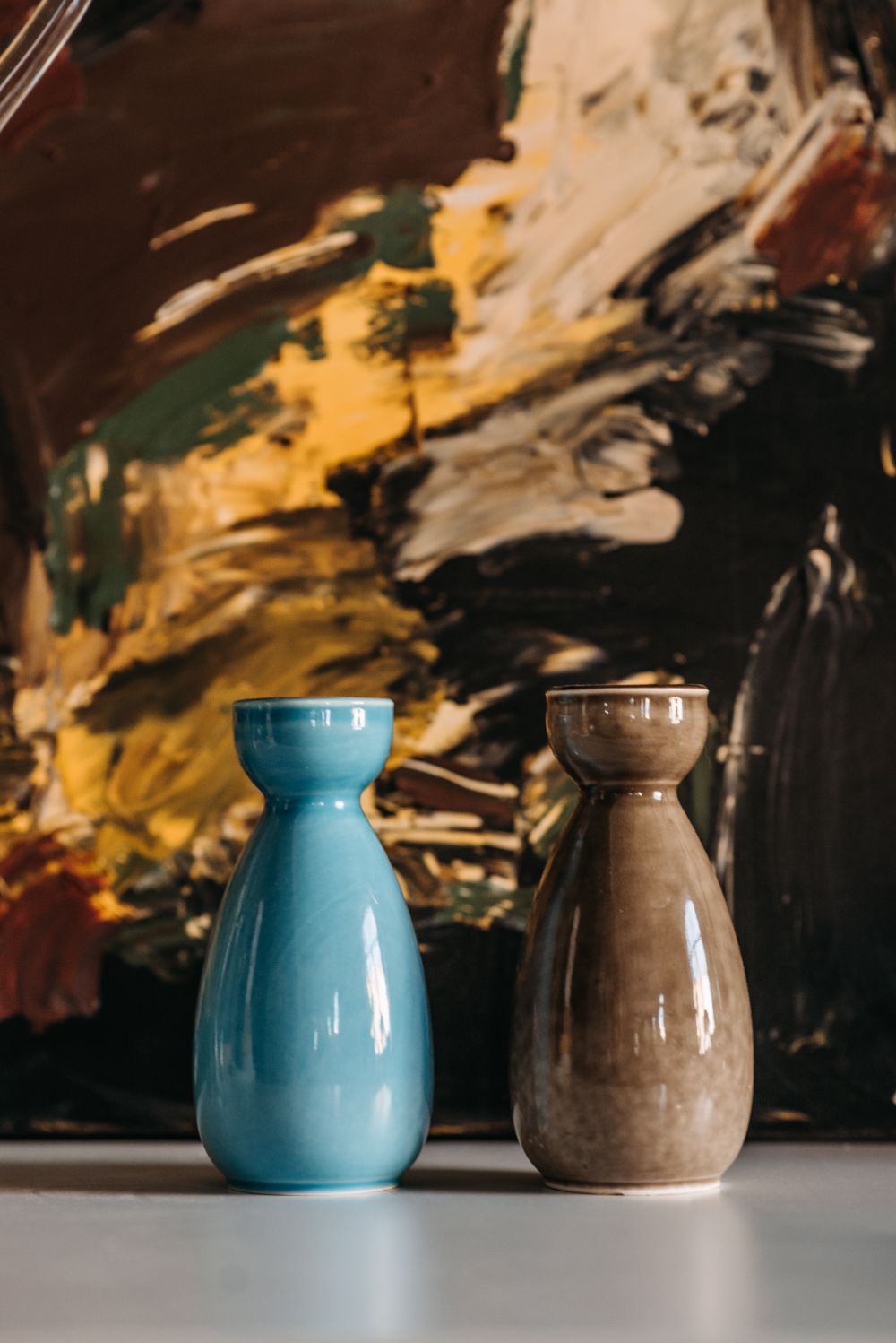 A tall, textured stoneware vessel resting on a rough stone plinth.